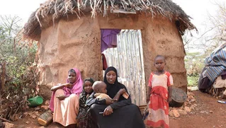 woman and children outside hut