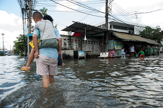 man carrying a child through floods