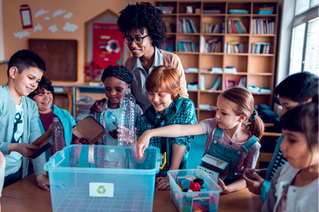 woman recycling in classroom with children