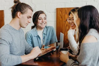 four people conversing at table